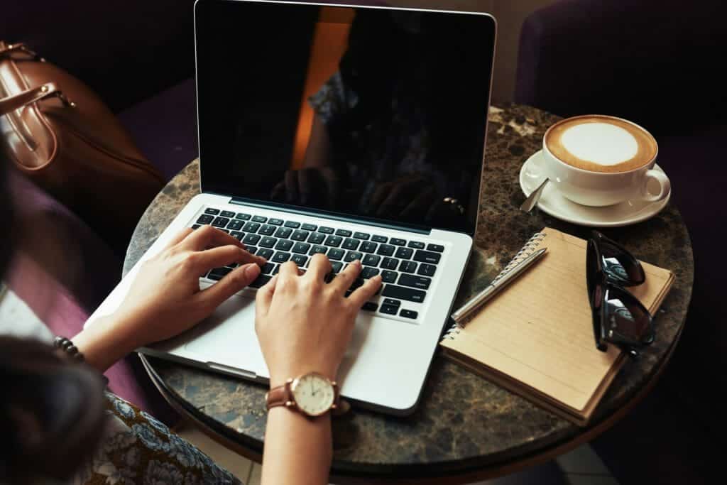 hands unrecognizable woman typing laptop cafe